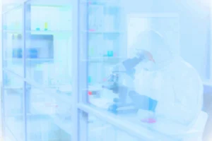 Cleanroom worker wearing full PPE and protective goggles